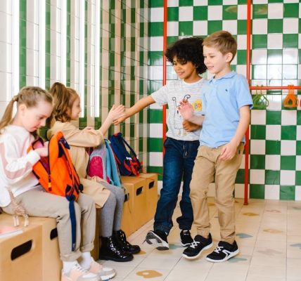 Kids interacting in a school locker room, showcasing friendship and happiness.