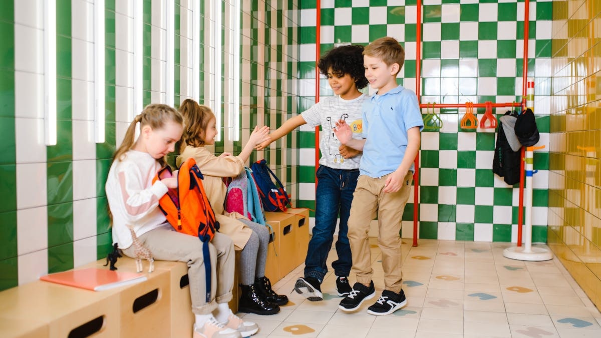 Kids interacting in a school locker room, showcasing friendship and happiness.