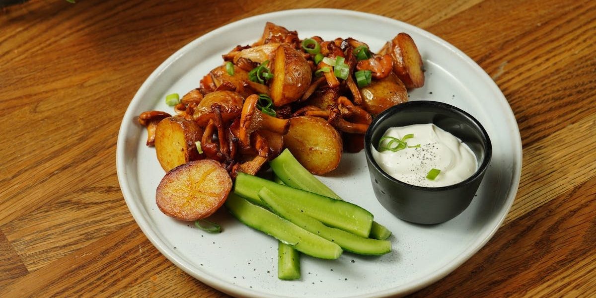 A delectable plate of roast potatoes served with chanterelle mushrooms and fresh cucumbers.