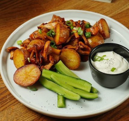 A delectable plate of roast potatoes served with chanterelle mushrooms and fresh cucumbers.